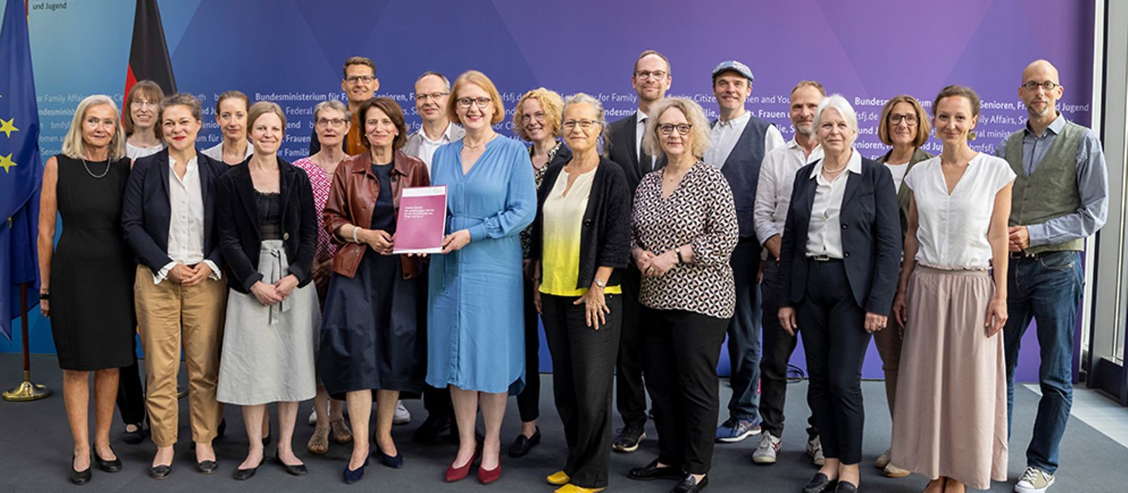 Gruppenfoto mit Lisa Paus, die einen Bericht in der Hand hält